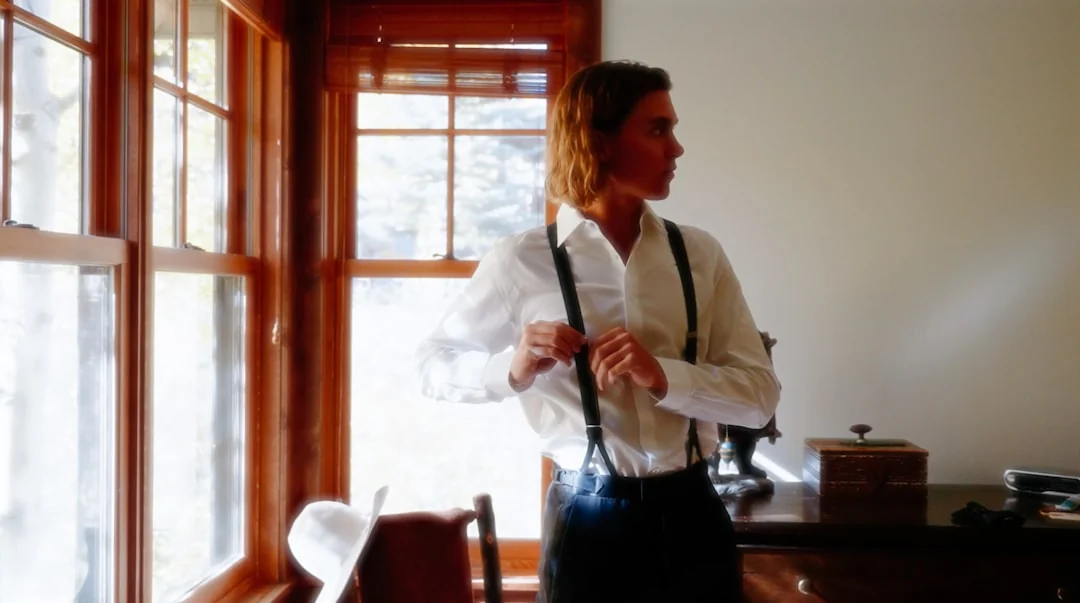 Una donna adulta in tuta rossa utilizza un aspirapolvere in un ambiente interno moderno, concentrata sulle attività di pulizia.